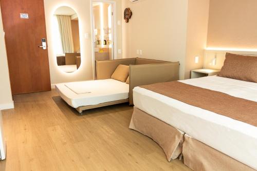 a hotel room with a bed and a couch at Littoral Express in João Pessoa