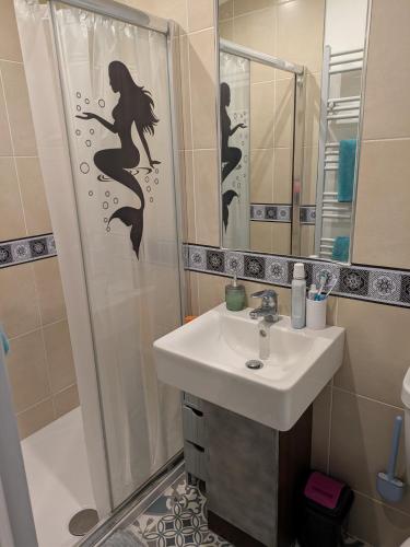 a bathroom with a sink and a shower with a mermaid sticker at Unique 2 bed lodge lyons Robinhood in Rhyl