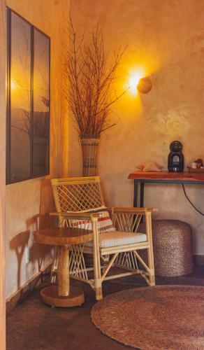 a room with a bench and a table with a vase at Hotel Pousada Rancho das Dunas in Santo Amaro