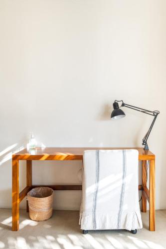 a desk with a lamp and a basket under it at Casa Lulú, Oasis with Pool and Panoramic Terrace in San José del Cabo