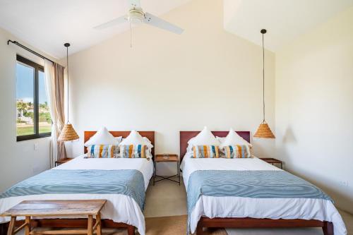 two beds in a room with white walls at Casa Lulú, Oasis with Pool and Panoramic Terrace in San José del Cabo