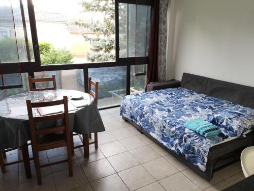 une chambre avec un lit, une table et une fenêtre dans l'établissement Maison séparée en deux appartements distincts, à Avignon