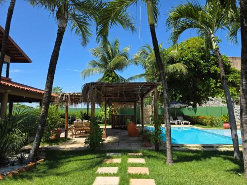 a resort with a swimming pool and palm trees at Kite and Dreaming Hotel in Cumbuco