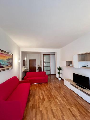 Lady's home في لا سبيتسيا: غرفة معيشة مع أريكة حمراء وتلفزيون