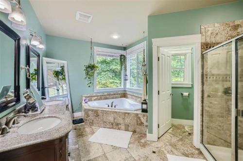 a bathroom with a tub and a sink at Utopia Luxury Stay - Olympia in Olympia