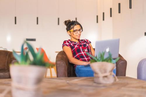 a woman sitting at a table using a laptop computer at Hotel Distrito Oeste in Donostia-San Sebastián