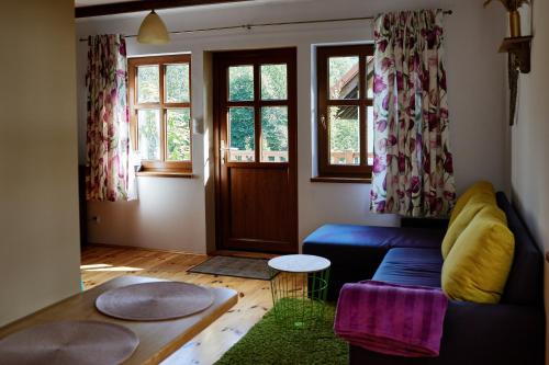 sala de estar con sofá azul y ventanas en Akacjowe Zacisze, en Stańkowa