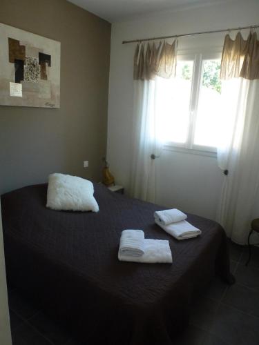 une chambre avec un lit avec deux serviettes dessus dans l'établissement Un cocon de détente entre mer et nature, à Zonza