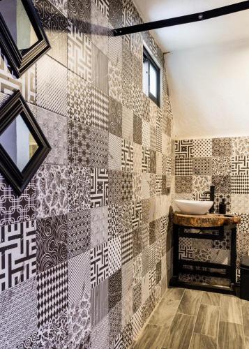 a bathroom with a tiled wall with a sink at La Campiña Glamping Club in Aguascalientes