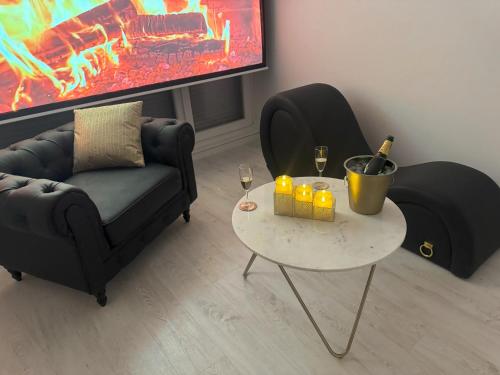 un salon avec un canapé et une table avec des bougies dans l'établissement Loveroom de luxe avec jacuzzi sauna vapeur écran 300 cm, à Metz