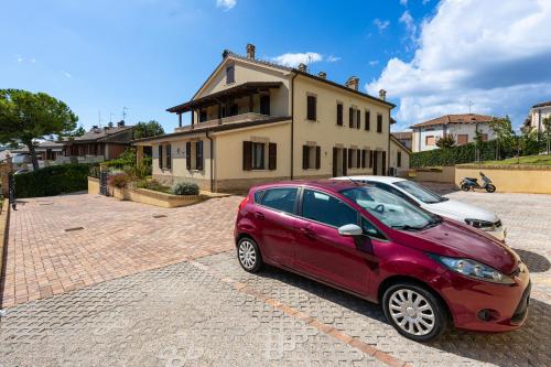 a red car parked in front of a house at BB Da La Mi Ma, Gradara in Gradara