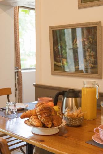 ClefsにあるLa Foutelaieのクロワッサン一皿とパンが付いたテーブル