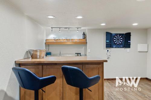 a kitchen with two blue chairs at a bar at Twin Lakes Village 3-Story Townhouse Golf Views Steam Shower Wet Bar Game Room Pool in Rathdrum