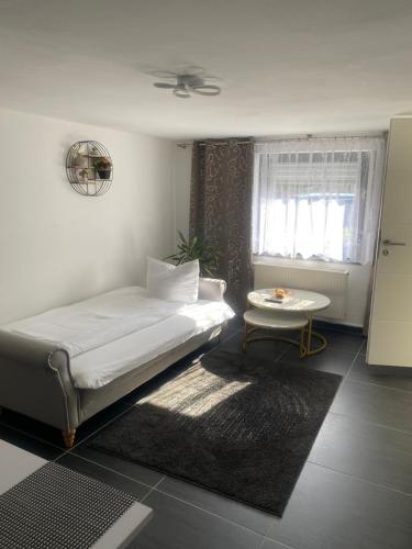a bedroom with a bed and a table and a window at Familie Moisil in Daun