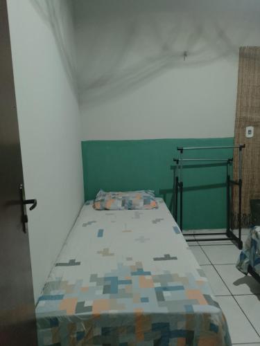 a bed in a room with a green wall at Pousada Recanto do Mar in Tutóia