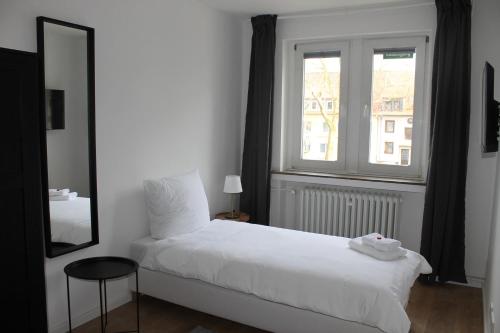 a bedroom with a white bed and a window at Gästehaus Friedrichstraße - Einzelzimmer im Zentrum in Paderborn