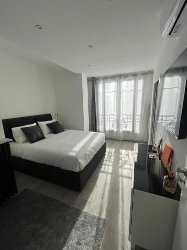 - une chambre avec un grand lit et des fenêtres dans l'établissement Le Montana - Festival-Centre-VueMer-Clim-Wifi, à Cannes