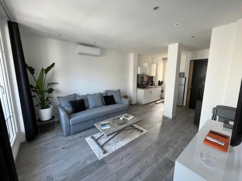 un salon avec un canapé et une table dans l'établissement Le Montana - Festival-Centre-VueMer-Clim-Wifi, à Cannes