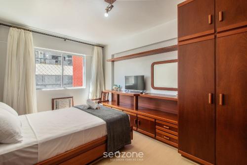a bedroom with a bed and a dresser and a mirror at Apto 3Q c/ varanda a 100m da Praia em BC EVZ0601 in Balneário Camboriú