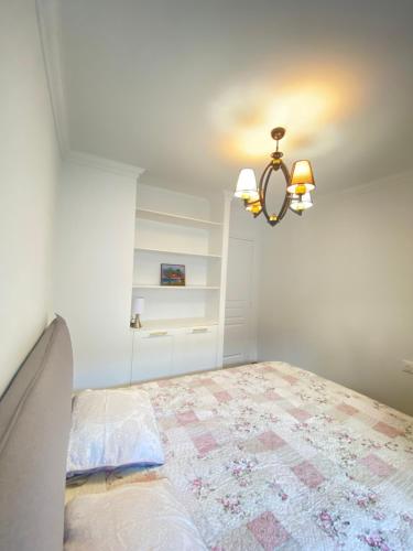 une chambre avec un lit et un lustre dans l'établissement Appart T2 refait à neuf 50m2, à Nice