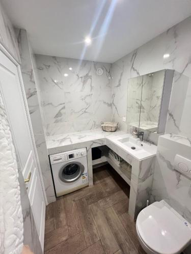 La salle de bains blanche est pourvue d'un lavabo et d'un lave-linge. dans l'établissement Appart T2 refait à neuf 50m2, à Nice