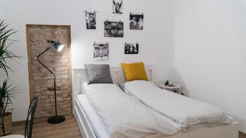 a white bed in a room with pictures on the wall at City Center Festival Apartment in Cluj-Napoca