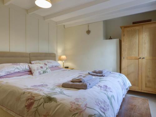 a bedroom with a bed with towels on it at 1 Gabberwell Cottages in Kingston