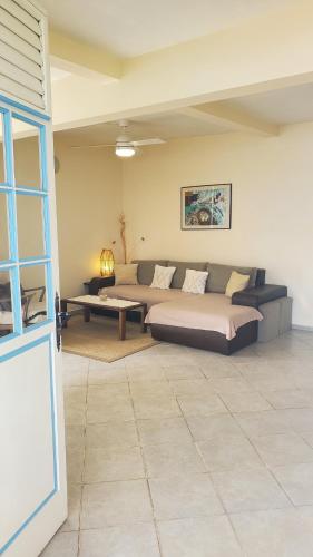 a living room with a bed and a couch at Flora in Le Marin
