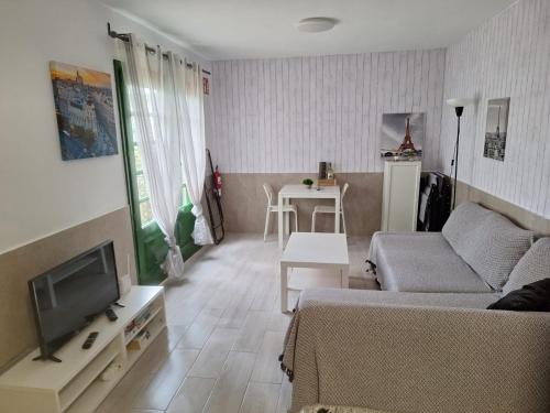 Una sala de estar con un sofá y un televisor. en Puerta del Sol II (Caleta de Fuste), en Caleta de Fuste