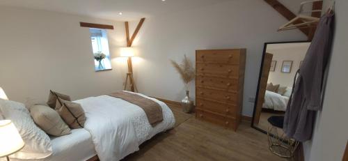 una camera da letto con un letto, un comò e uno specchio di Oak Cottage - Perfect for Golfing, Walking & Relaxing ad Abergavenny