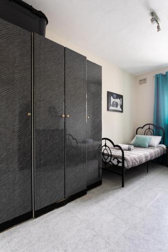 a bedroom with a bed and a black wardrobe at Mellieha Letcom Apartment in Mellieħa