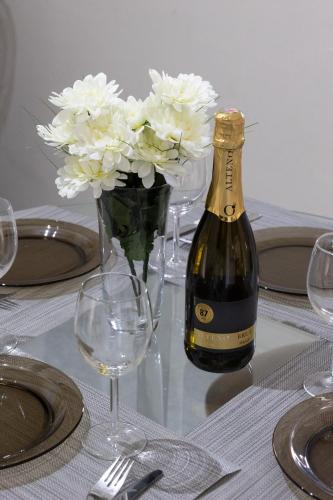 a bottle of wine and a vase of flowers on a table at Mellieha Letcom Apartment in Mellieħa