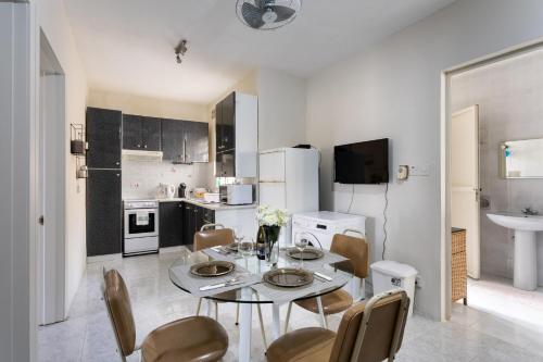 a kitchen with a table and chairs in a room at Mellieha Letcom Apartment in Mellieħa