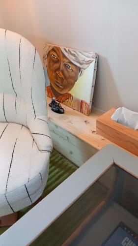 a painting of a woman on a wall next to a couch at Chambres d'hôtes bord de Loire in Saint-Mathurin