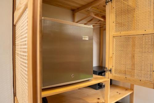 a closet with a metal door and wooden shelves at Pandanus Lodge & Retreats Bungalow Heliconia in Cariblanco