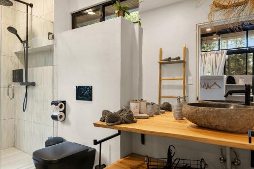 a bathroom with a sink on a wooden counter at Pandanus Lodge & Retreats Bungalow Heliconia in Cariblanco