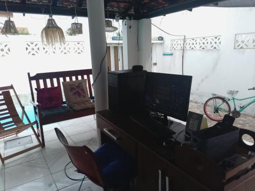a room with a desk with a computer and a chair at Pousada Recanto do Mar in Tutóia