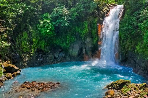 a waterfall in the middle of a river at Pandanus Lodge & Retreats Bungalow Heliconia in Cariblanco