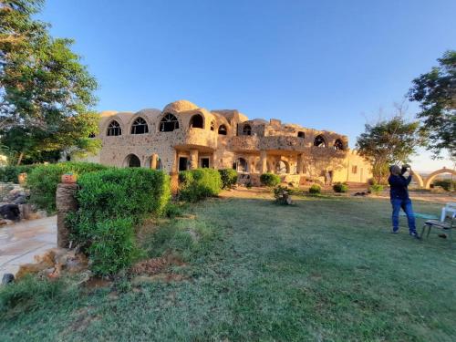 a person taking a picture of a building at Oasis Panorama in Bawiti