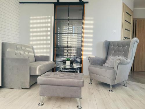 a living room with two chairs and a coffee table at Mieszkanie, kawalerka na wynajem kilkudniowy budynek 48 mieszkanie nr20 in Lubawa