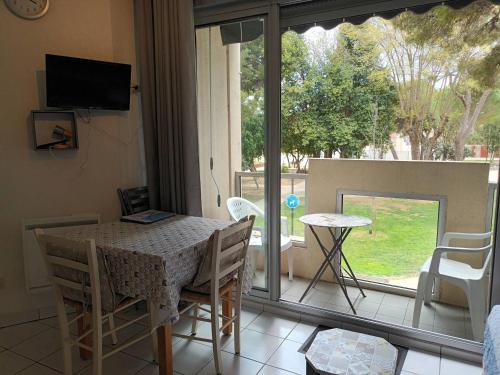 une salle à manger avec une table et des chaises et une fenêtre dans l'établissement Charmant T2 avec balcon, animaux admis, près des thermes - FR-1-503-153, à Balaruc-les-Bains
