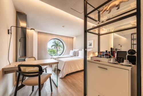 a hotel room with a bed and a desk and a table at Hotel Unique in Sao Paulo