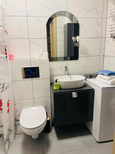 a bathroom with a sink and a toilet and a mirror at Mieszkanie, kawalerka na wynajem kilkudniowy budynek 48 mieszkanie nr20 in Lubawa