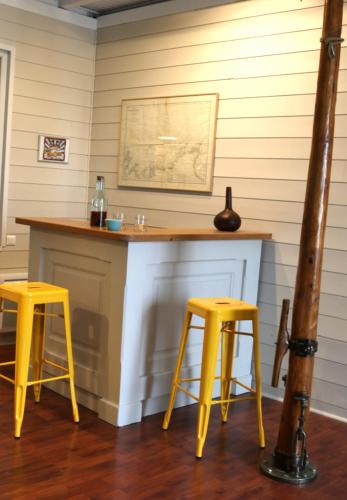 a bar with two yellow stools in a room at Grand Appartement, Port La Houle, Vue Mer in Cancale