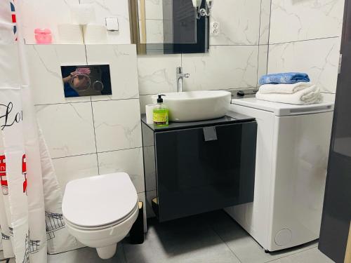 a bathroom with a white toilet and a sink at Mieszkanie, kawalerka na wynajem kilkudniowy budynek 48 mieszkanie nr20 in Lubawa