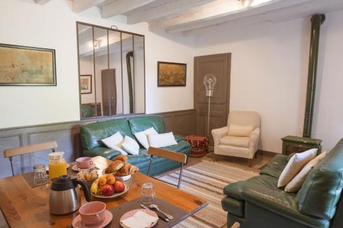 a living room with a green couch and a table at La Foutelaie in Clefs-Val d'Anjou