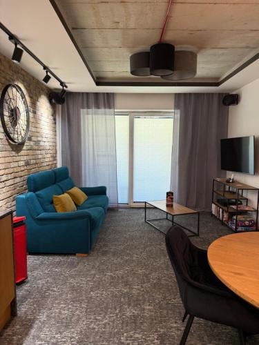 a living room with a blue couch and a table at Apartament Aleja Wolności in Nowy Sącz