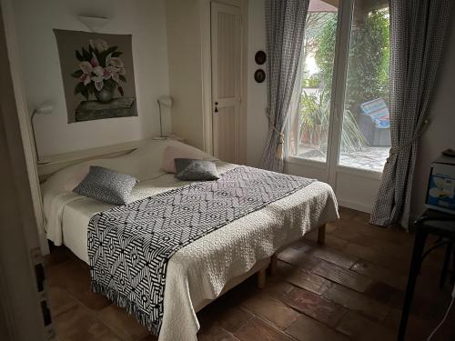 un dormitorio con una cama y una ventana en Villa Magnifique vue mer, en La Croix-Valmer