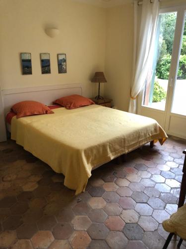 Un dormitorio con una cama grande con almohadas naranjas. en Villa Magnifique vue mer, en La Croix-Valmer