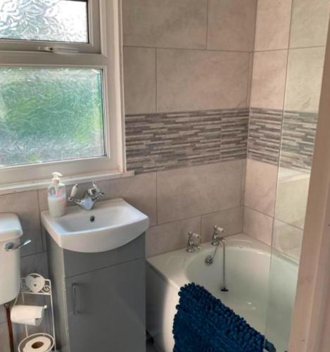 ein Badezimmer mit einem Waschbecken und einer Badewanne neben einem WC in der Unterkunft Chalets on Glan Gwna Holiday Park - Sleeps up to 10 in Caeathro